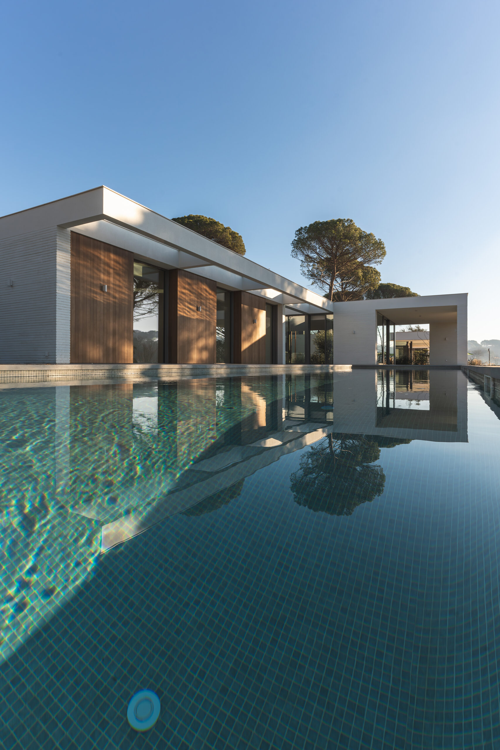 Modern white and wood luxury house with pool in a private complex. Vertical